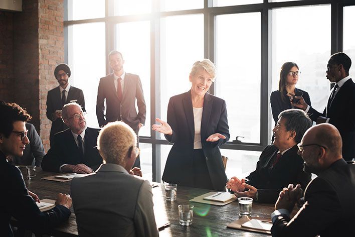 happy, smiling corporate meeting attendees applauding